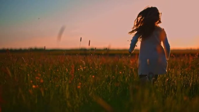 日落时分，带着一束鲜花在高高的草丛中奔跑的SLO MO小女孩