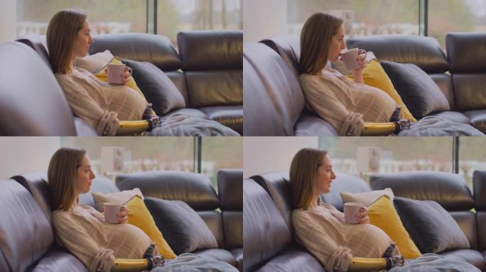 假肢孕妇在家沙发上放松，热饮看电视 -- 慢动作拍摄