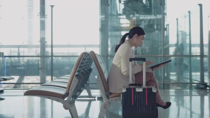 亚洲旅行商务女性在机场等待飞机。