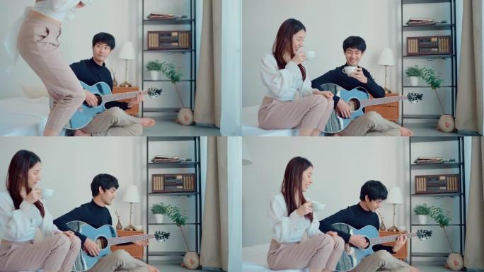 英俊的男人在轻便公寓的床上弹吉他和女友唱歌。