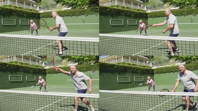 快乐的高加索高级夫妇在打了一场比赛后在室外网球场打双打