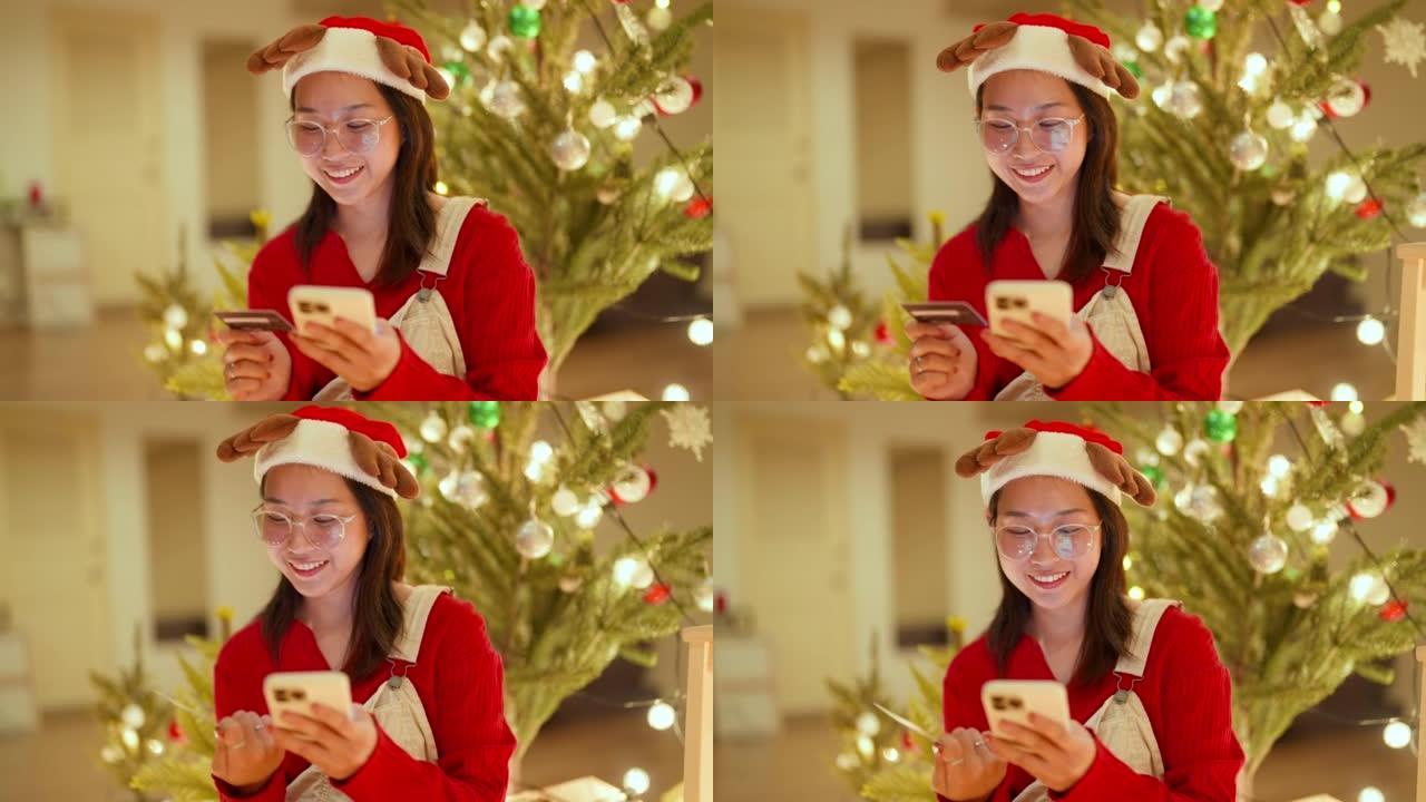 美丽的年轻亚洲女性在圣诞节促销期间网上购物。