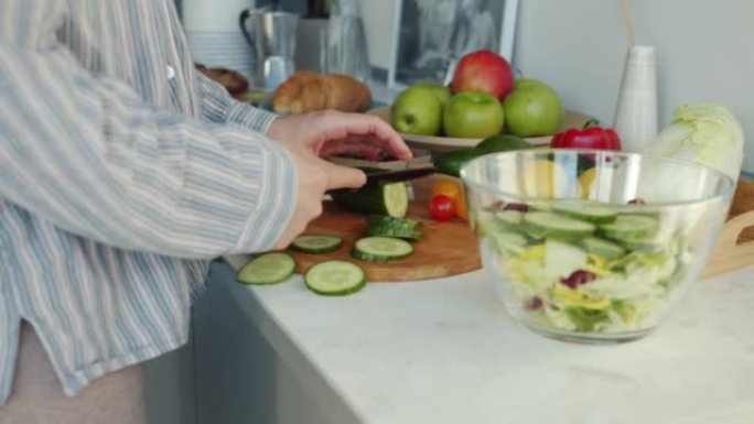女性用刀切割新鲜蔬菜的特写镜头在家厨房做沙拉