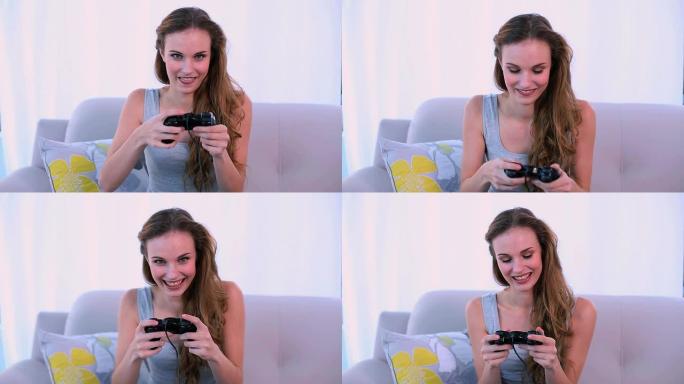 微笑的模特在沙发上玩电子游戏