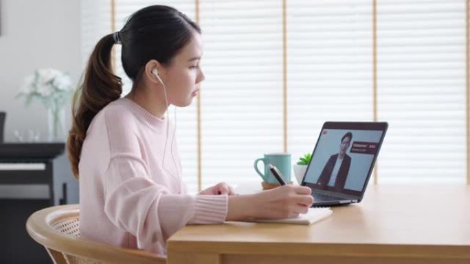 后视图年轻的亚洲女性收听虚拟商务会议网络研讨会、管理市政厅或全体人员在家检疫社交远程会议，以亚洲演讲