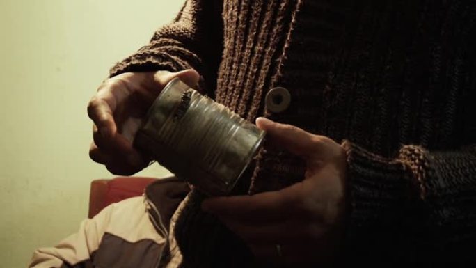 男性手拿着一个旧锡罐。特写。