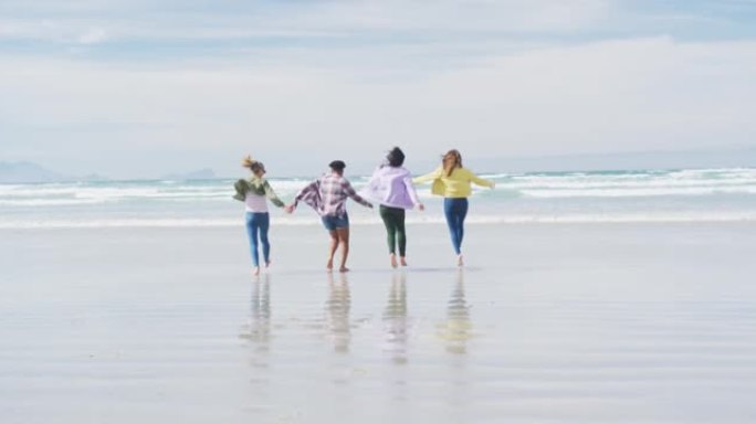 快乐的一群不同的女性朋友玩得开心，在海滩上跑步