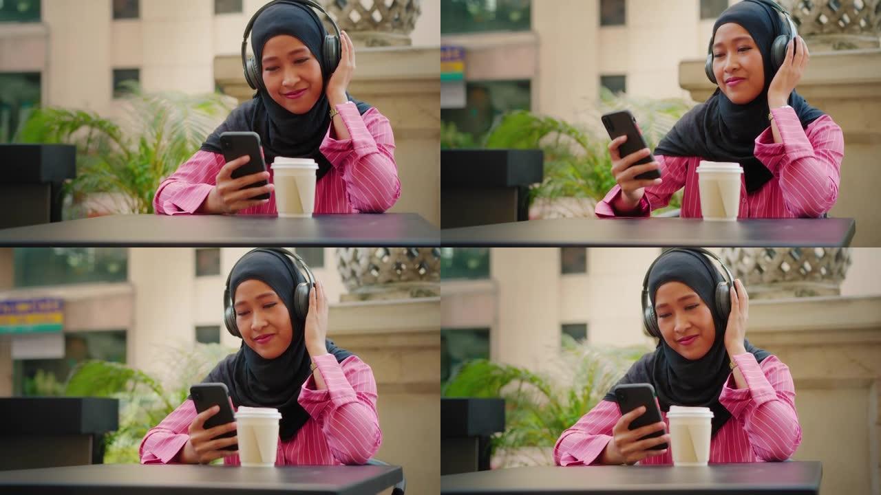 现代穆斯林在咖啡馆用手机看电影。