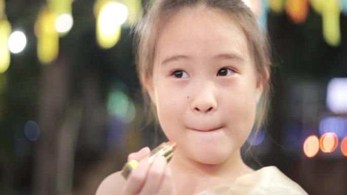 可爱的亚洲女孩涂口红的特写脸