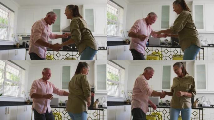 高加索高级夫妇在家里的厨房里一起跳舞