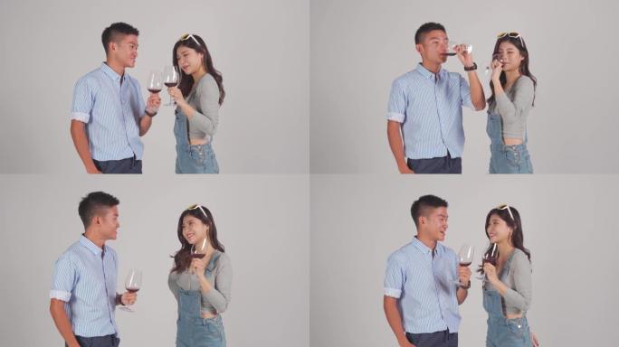 时尚的亚洲中国夫妇与酒杯夏季穿工作室拍摄裁剪witg灰色背景
