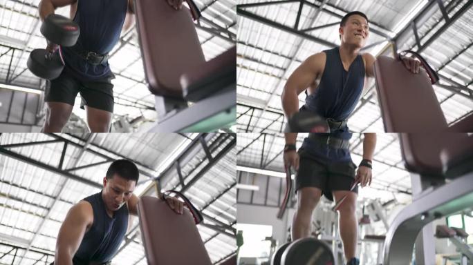 亚洲男子在低角度视野中举起哑铃锻炼手臂和背部的肌肉