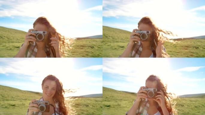 4k视频片段，一位迷人的年轻女子在旷野远足时拍照
