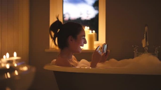 4k视频拍摄了一名年轻女子在泡泡浴中的视频通话中吹吻的镜头