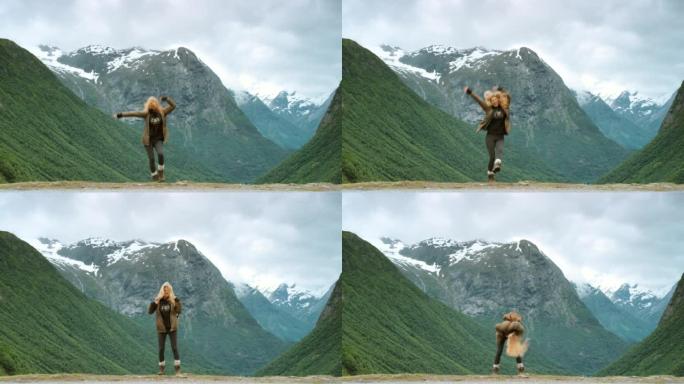 4k视频片段，一名年轻女子在Stryn探索山脉时兴奋地跳跃