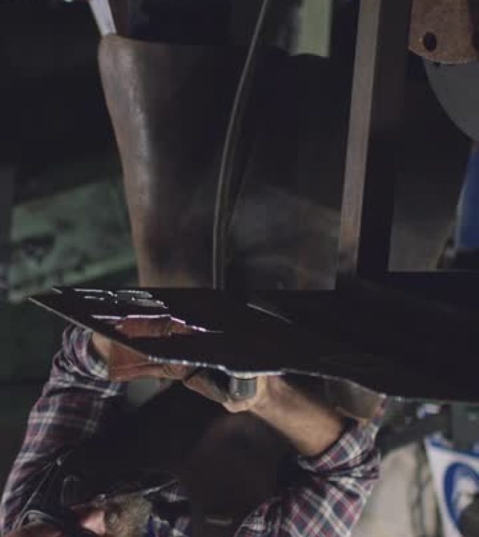 男性铁匠使用等离子切割机从锻造的钣金切割形状的垂直视频