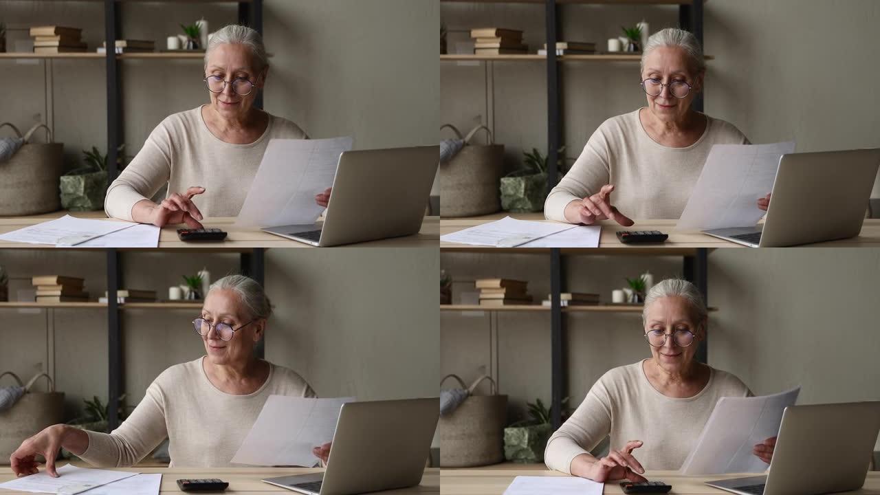 年长的妇女使用笔记本电脑支付账单在计算器上计算金额