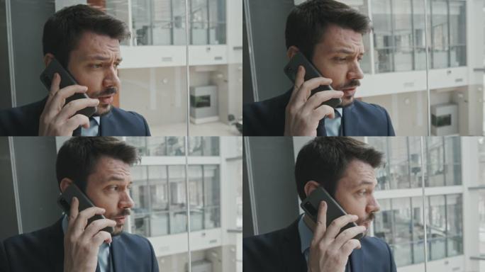 男性倡导者在玻璃升降机上通过电话交谈的特写镜头