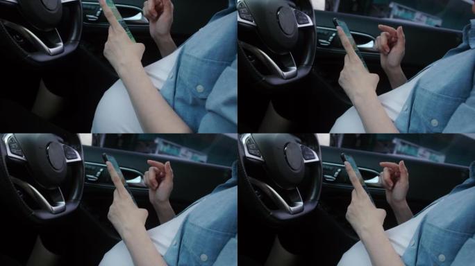 特写怀孕的母亲系好安全带，在车里使用智能手机。