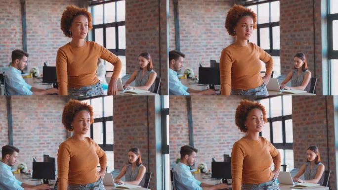 办公室里严肃的女商人肖像，同事在背景中工作