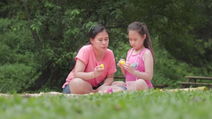 亚洲女孩和她的母亲为复活节画鸡蛋