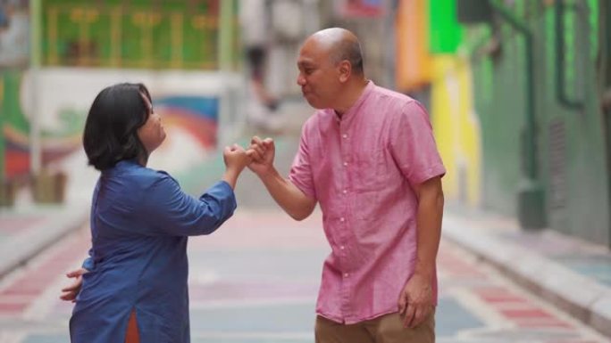 快乐亚洲马来自闭症唐氏综合症女性小指承诺与她的父亲在城市街道