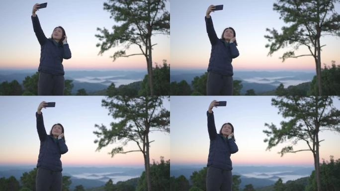 女旅行者在山地自然国家公园用智能手机拍摄风景秀丽的照片