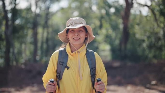 年轻女子徒步旅行，看着相机