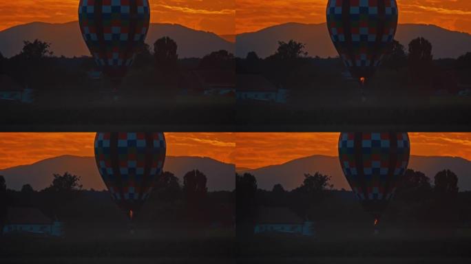 方格热气球在日落时漂浮在农村地区