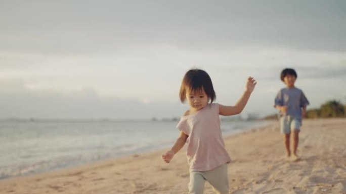 亚洲男孩和小女孩在海滩上散步。