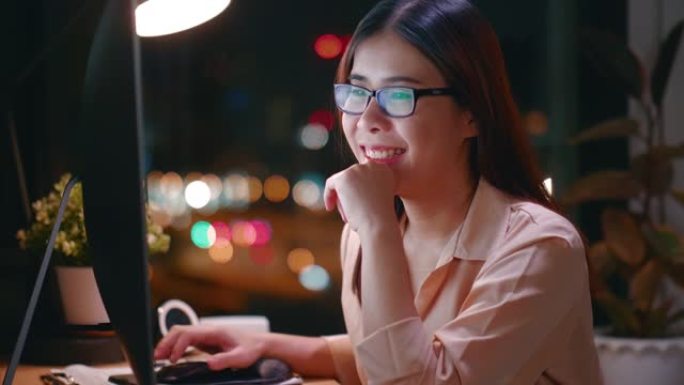 年轻女子笑着看电脑屏幕之夜