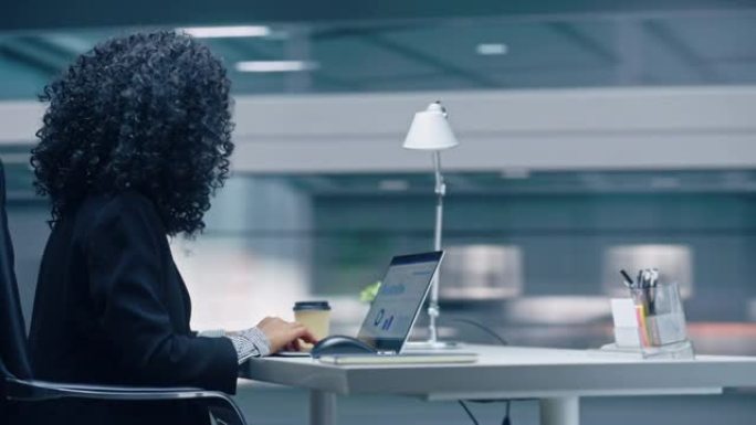 360学位办公室: 黑人女商人坐在办公桌前，在笔记本电脑上工作。微笑着与大数据电子商务合作的成功非洲