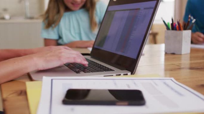 女性在家工作时使用笔记本电脑的中段