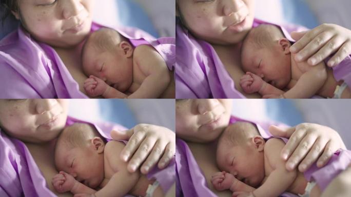 在医院的母亲温暖的胸前睡觉的新生婴儿