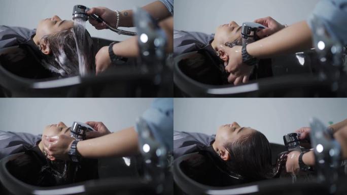 正上方的亚洲中国女性闭着眼睛躺在美发沙龙洗头