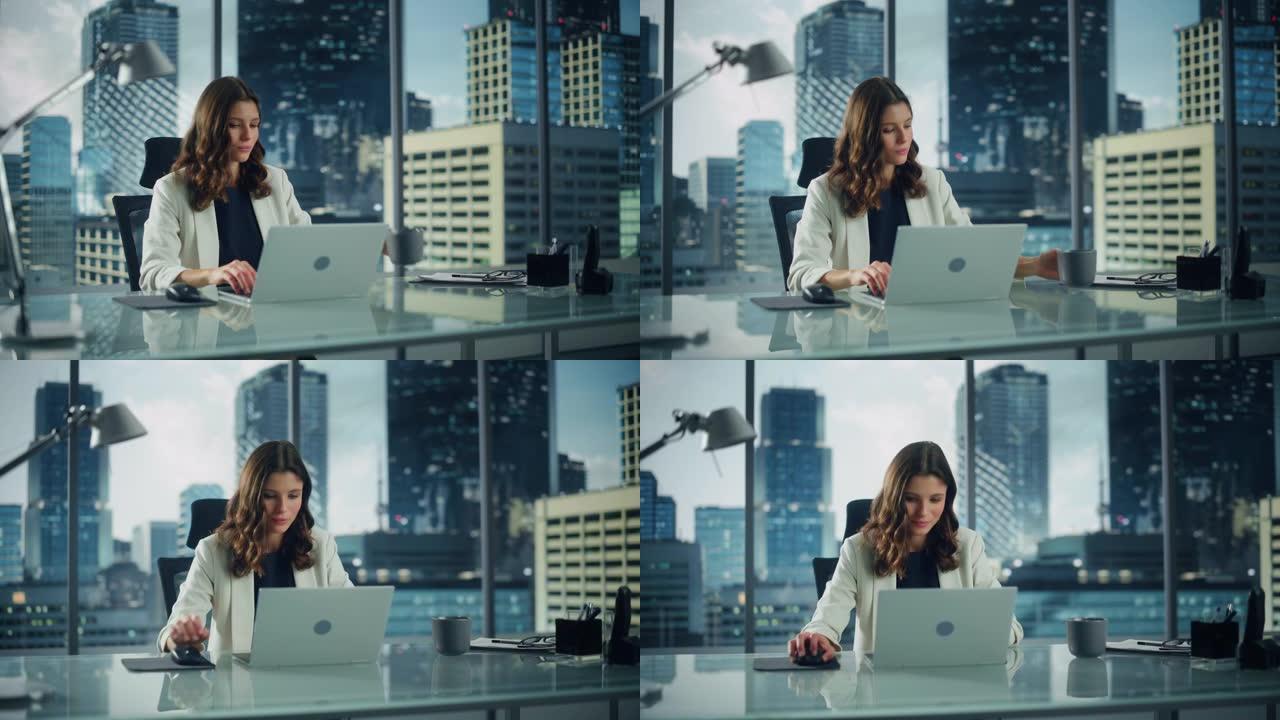 成功的年轻女商人坐在办公桌前在大城市办公室的笔记本电脑上工作的肖像。专业社交媒体战略经理计划颠覆性电