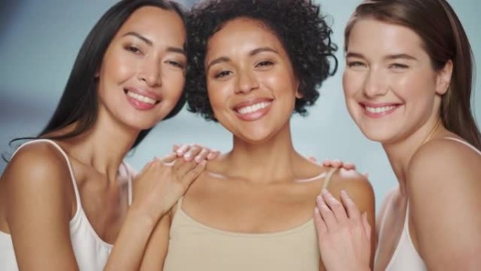 三个不同的多种族模型在孤立的背景上的美丽肖像。性感快乐的亚洲、黑人和高加索女性，拥有自然健康的皮肤。
