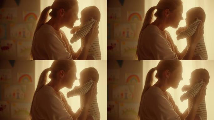 快乐母亲在舒适温暖的儿童卧室里抱着一个可爱的新生婴儿的真实镜头。有爱心的妈妈和幼儿在家里结为纽带。童