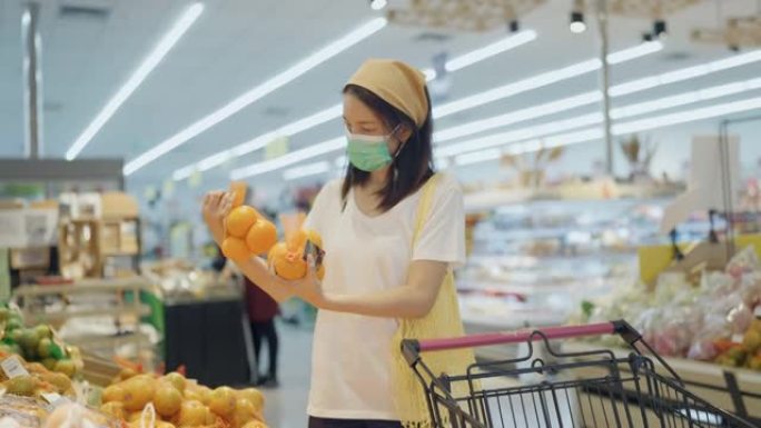 亚洲妇女戴着保护口罩购物。