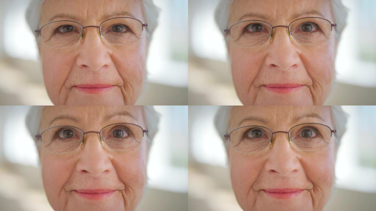 戴眼镜的高级女性眼睛的特写脸，以改善视力。一位戴着眼镜的老年女士的肖像，以帮助视力或近视。态度积极的