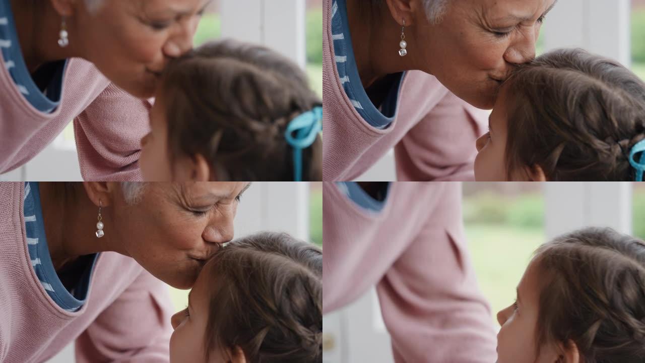 祖母轻轻地亲吻额头上的小女孩，表示对孙女的爱骄傲的奶奶感受到对孙子4k的爱