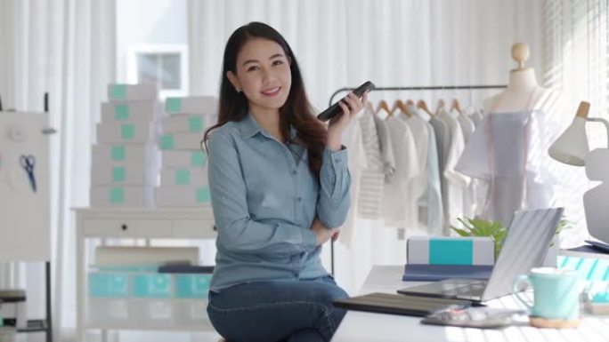 肖像年轻有吸引力的亚洲女性所有者创业企业看着相机工作在家中的盒子准备包裹递送中小企业供应链，采购，全
