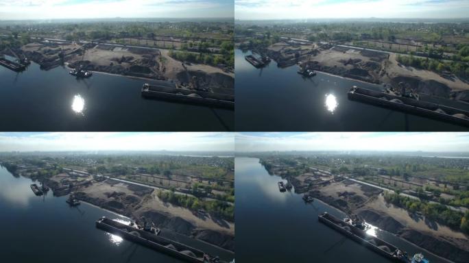 港口起重机早上在工业区的河上装载沙子和碎石。空中全景。