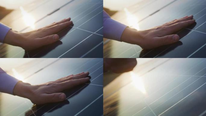 年轻的工程师hand的特写镜头正在日落时检查太阳的运行和光伏太阳能电池板的清洁度。概念。可再生能源，