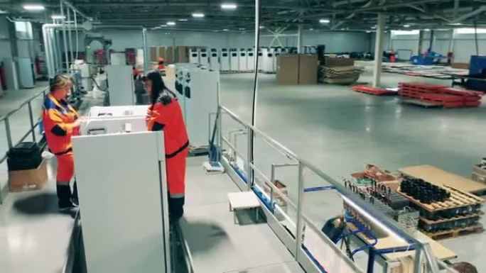 女工程师正在工厂里组装冰箱。工业工厂装配线。