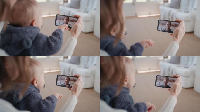 母亲和婴儿使用智能手机进行视频聊天，父亲在屏幕上挥舞着婴儿，享受通过手机连接与家人交流4k