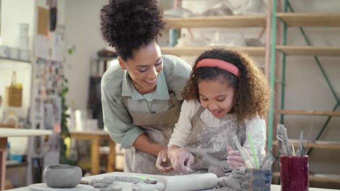 陶艺班，儿童学生和设计老师在艺术工作室，儿童工作室，创造力和女孩的陶瓷项目中检查儿童雕塑模具过程