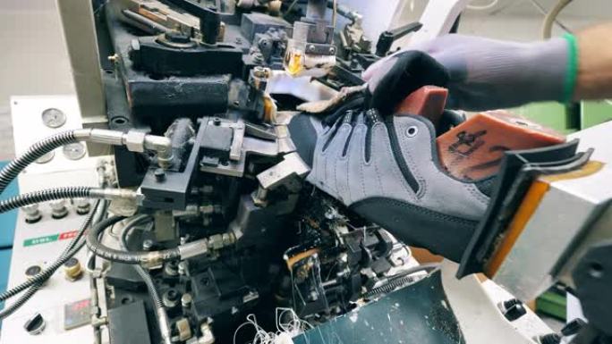 工业工人正在使用一种机制来生产运动鞋。鞋类生产设施。