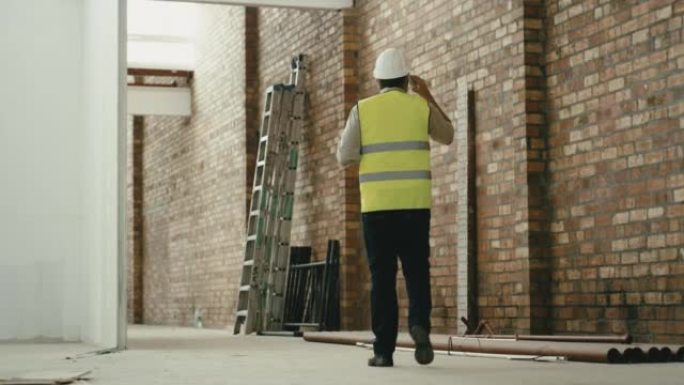 Construction worker talking on phone call and walk