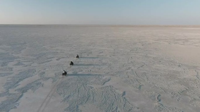 空中飞越游客在博茨瓦纳壮观的Makgadikgadi平底锅的广阔空间里骑四轮摩托的乐趣